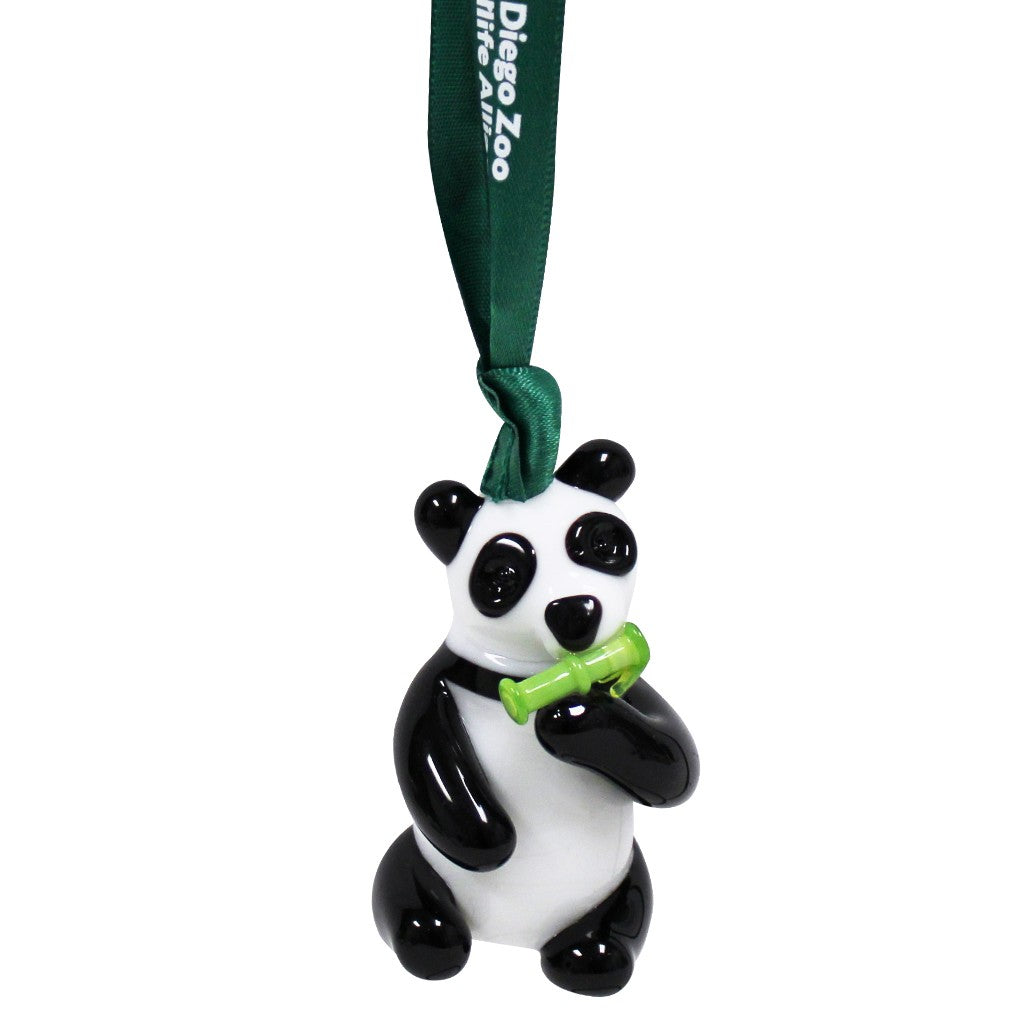 A glossy black and white panda glass ornament holding a green bamboo shoot, hanging from a dark green ribbon printed with 'Dieges Zoo'.