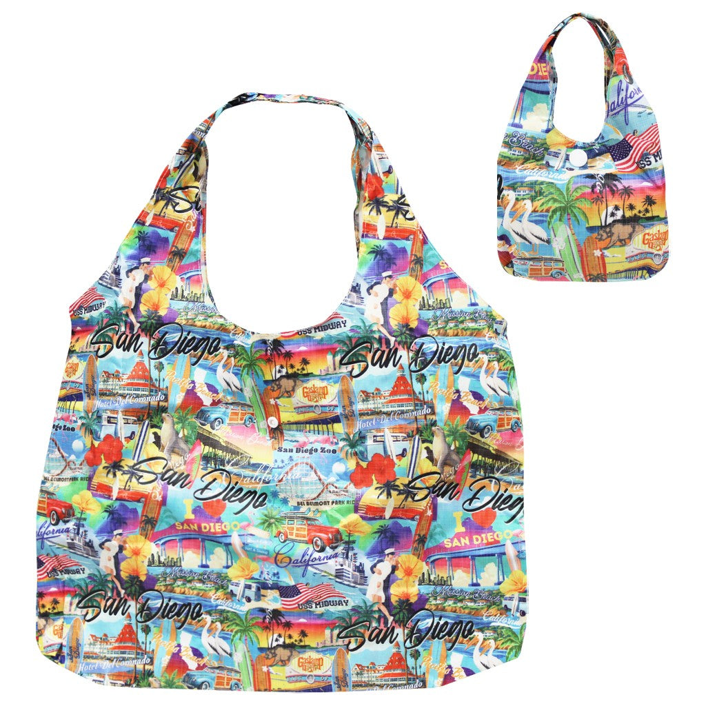 A reusable tote bag with a colorful San Diego collage print featuring palm trees, landmarks, and the word 'San Diego' repeated across the front, foldable
