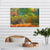 Canvas Print Painting of an elephant in a forest on a wall above a table with a plant and decorative items.