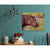 Hippo Canvas Print painting on a teal wall with decorative items on a table.