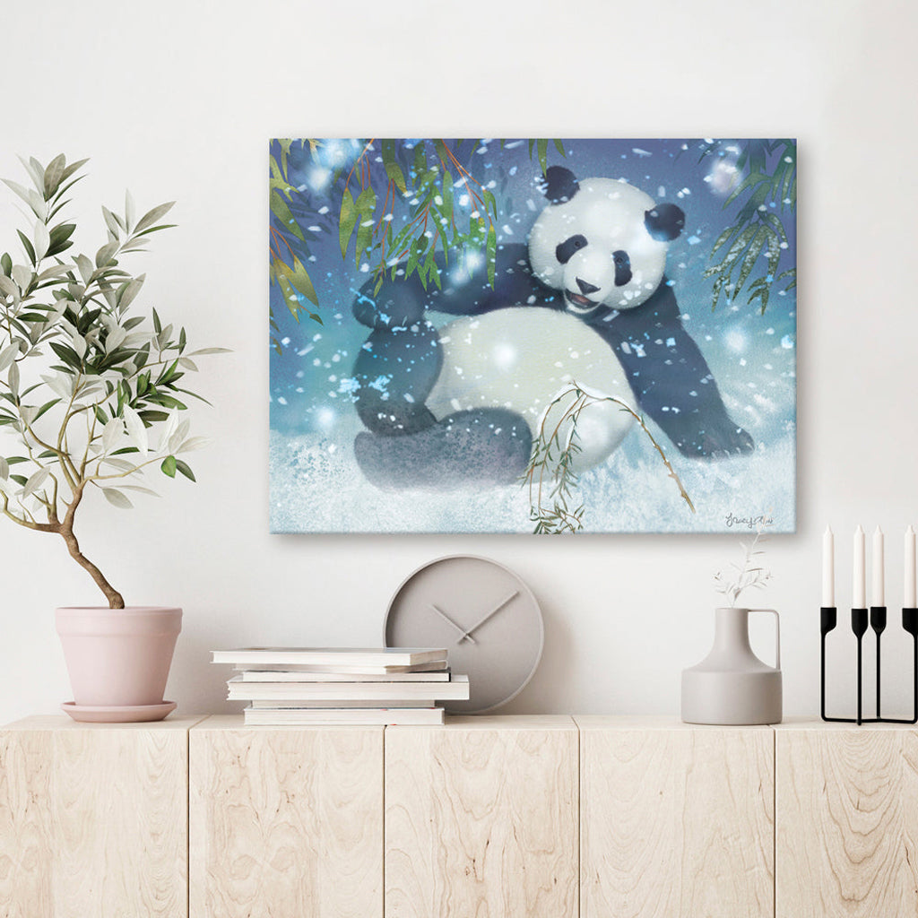 Canvas print of a panda bear in a snowy scene hanging on a wall above a wooden shelf.