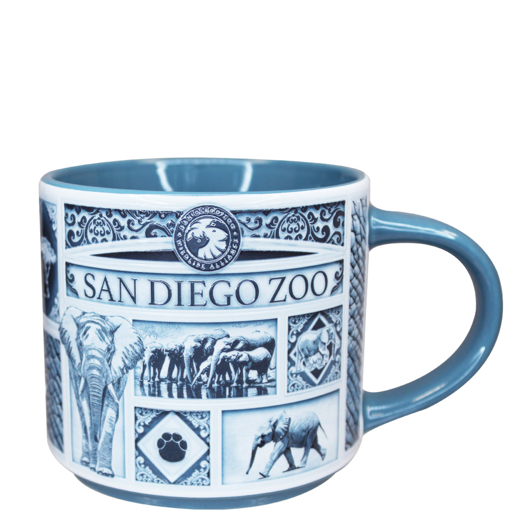 A Delft style ceramic San Diego Zoo mug with a blue handle and interior, decorated with blue and white illustrations of elephants and the San Diego Zoo logo.