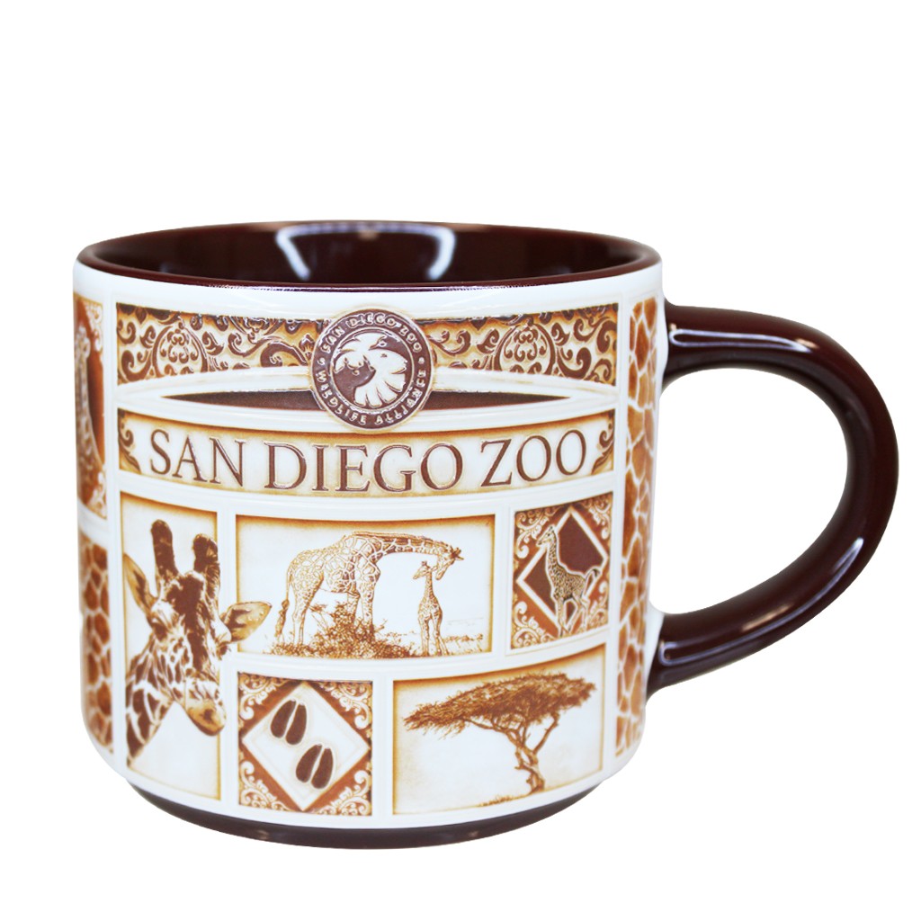 A San Diego Zoo &amp; Safari Park Delft-style ceramic mug with a white exterior decorated with brown safari-themed illustrations and text, featuring a dark brown handle and interior.