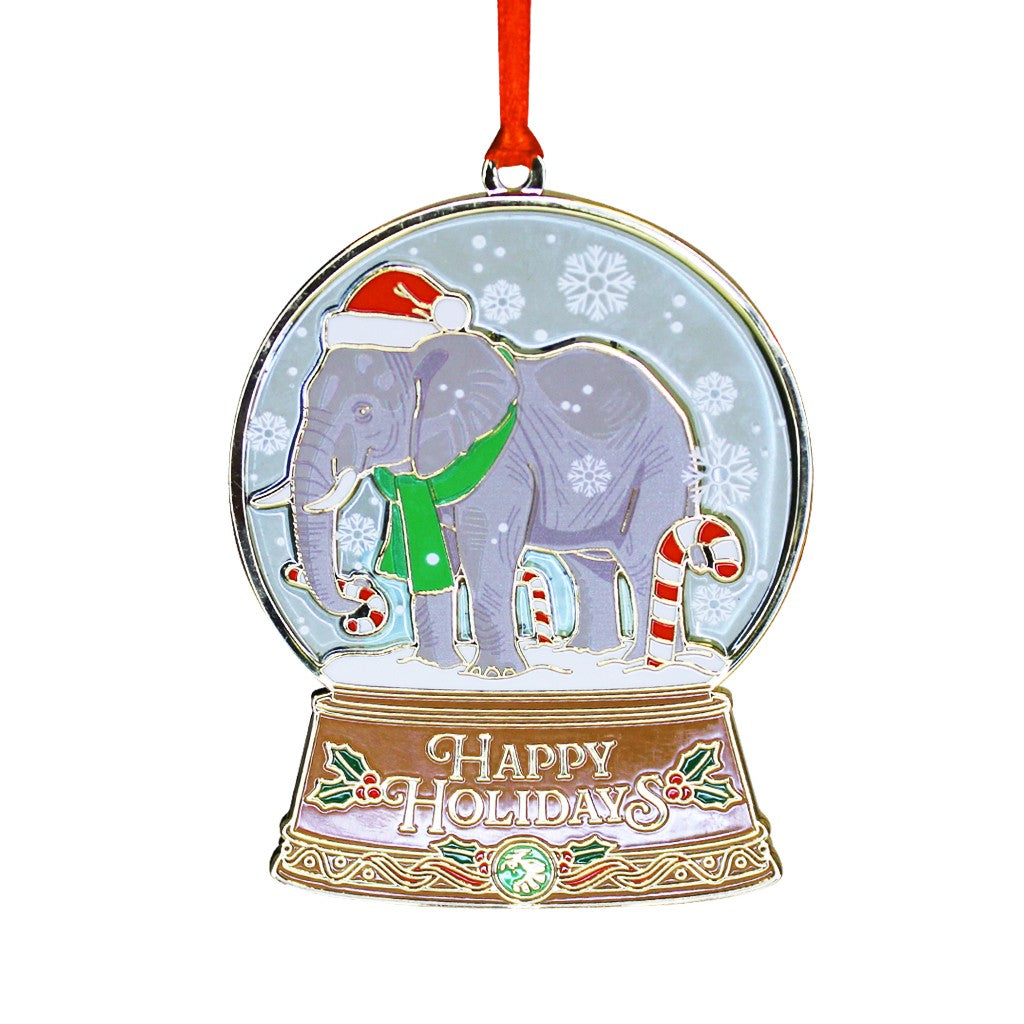 A festive Christmas ornament shaped like a snow globe, featuring a gray elephant wearing a red Santa hat and green scarf, surrounded by candy canes and snowflakes, with a gold-toned base that reads 'Happy Holidays' and hangs from a red ribbon. San Diego Zoo Wildlife Alliance 