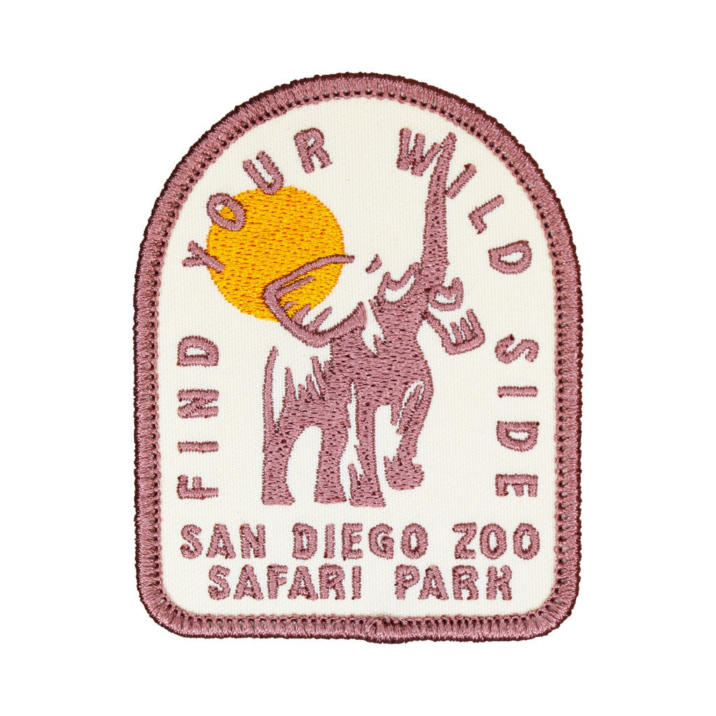 An embroidered patch for San Diego Zoo Safari Park featuring a dusty rose elephant silhouette, a yellow sun, and the text 'FIND YOUR WILD SIDE' and 'SAN DIEGO ZOO SAFARI PARK' on an off-white background.