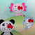 Hello Kitty wildlife plushies- a giant panda, an axolotl, and a shark with bows on a light green background.